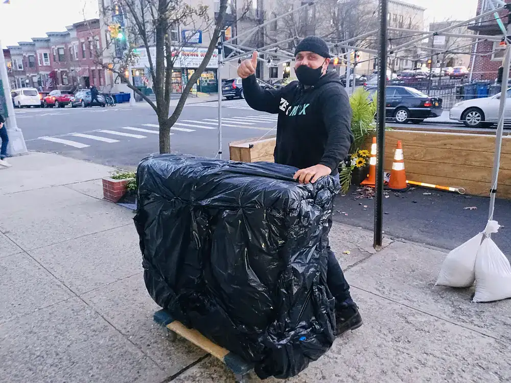 ZeroMax mover with wrapped furniture on a city sidewalk for a move from NYC to San Diego